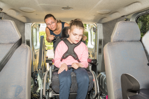 disabled child helped into van